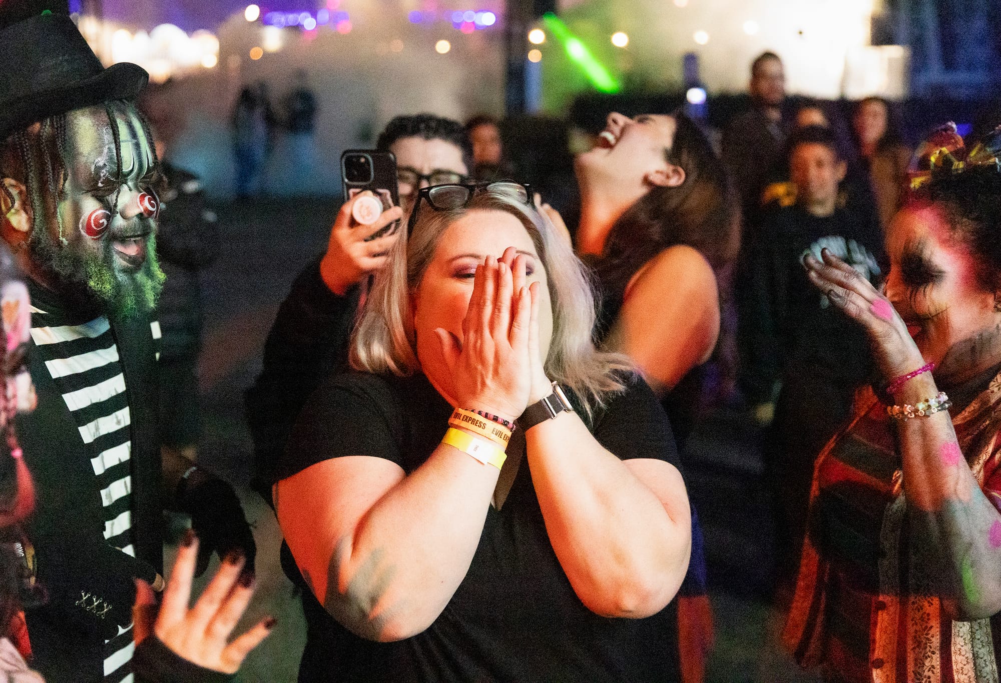 A woman screams as people in horror makeup stand around her.