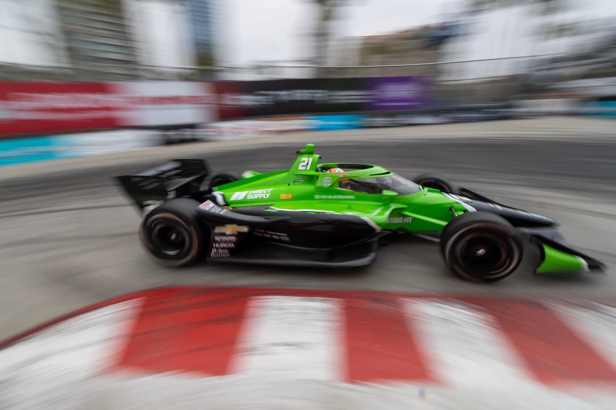 A green and black race car takes a sharp turn.