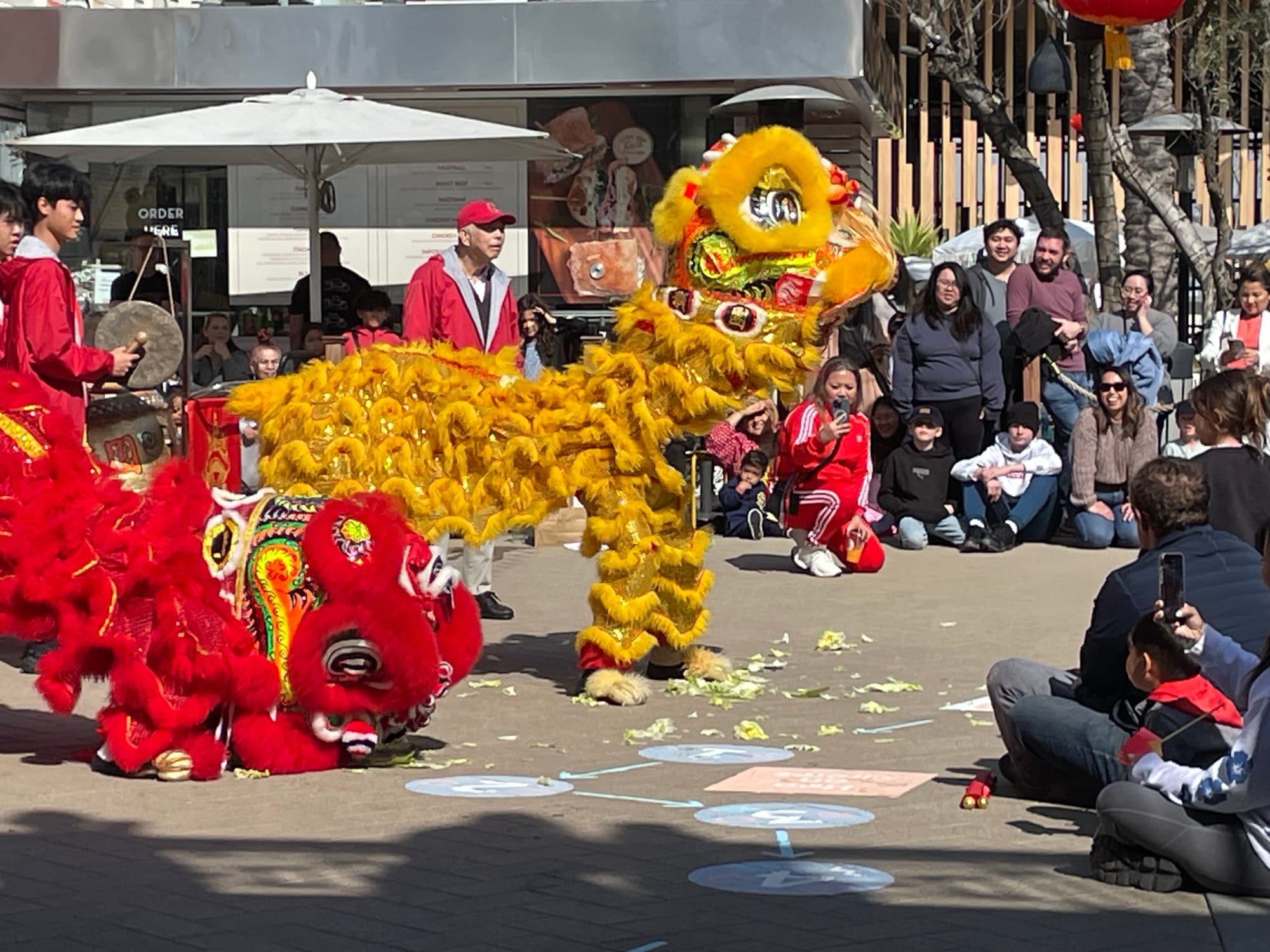 People watch large yellow and red dragons at a parade.