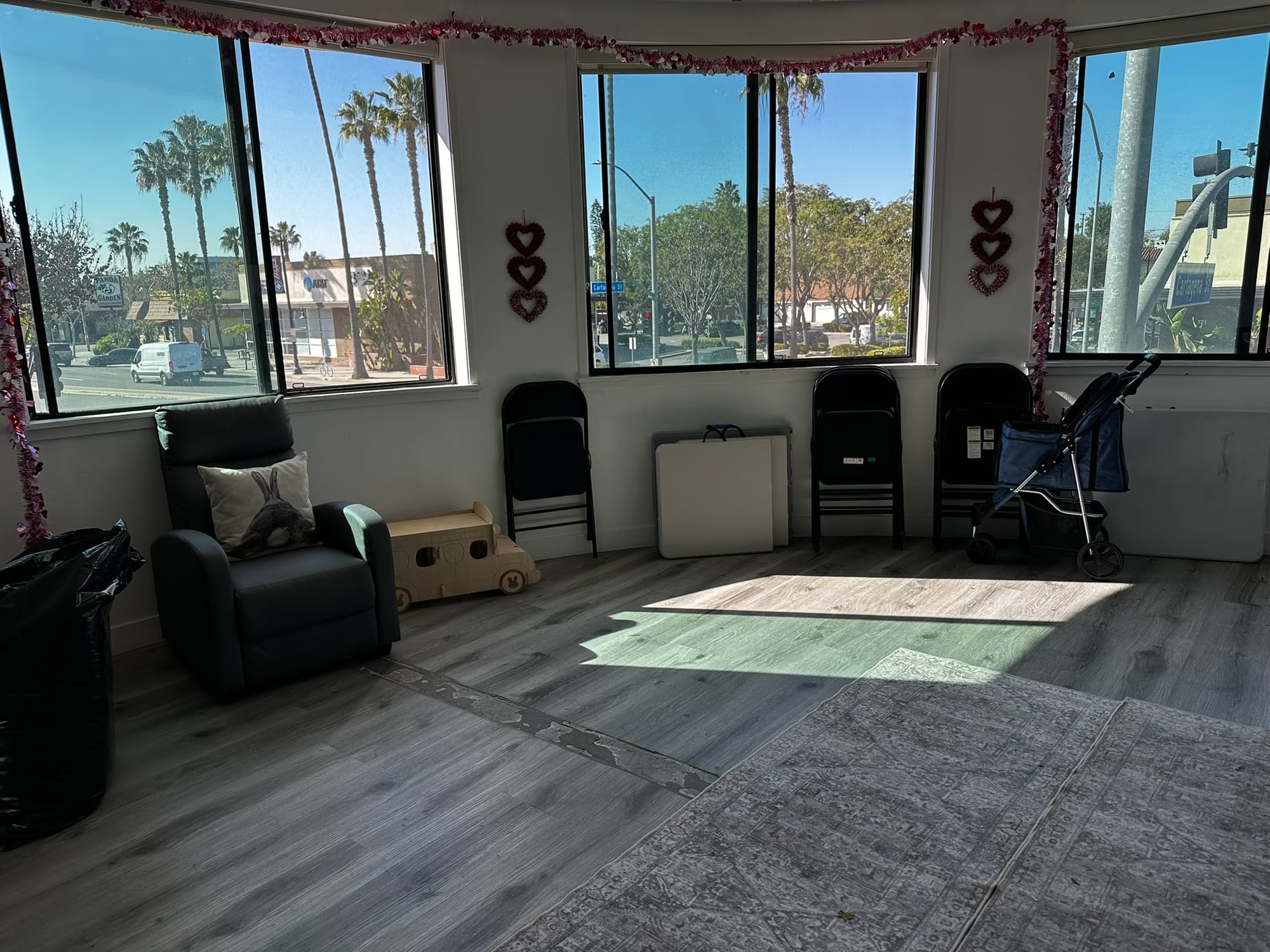 A room overlooking a street has folding chairs standing against the wall.