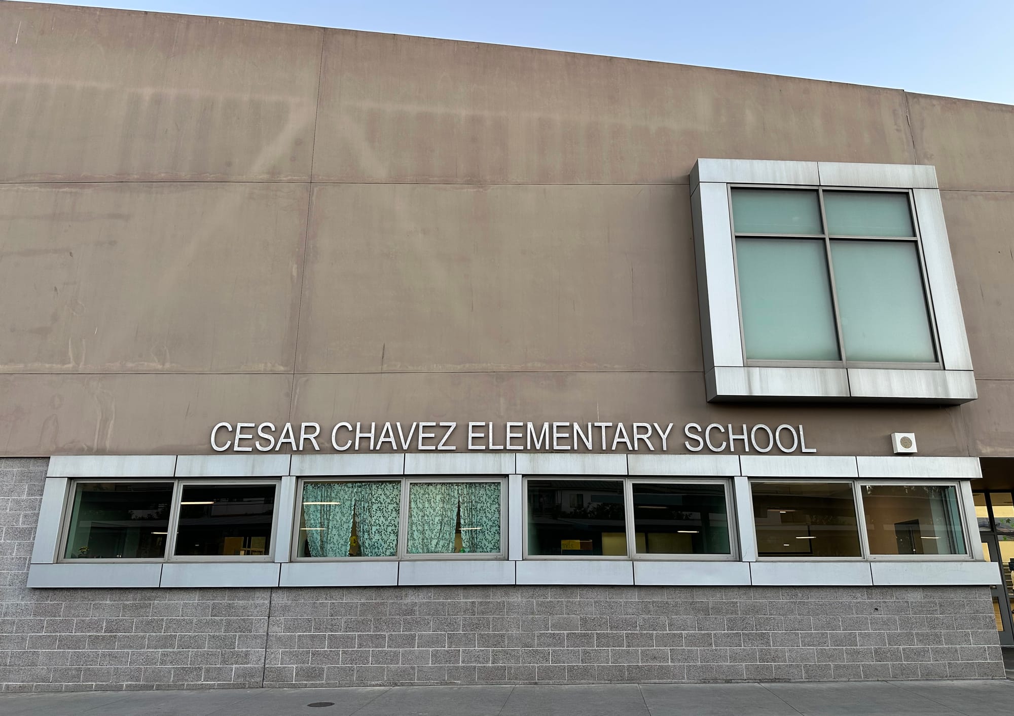 Tan building with a row of windows below the words "Cesar Chavez Elementary School."