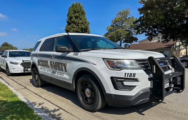 White sports utility vehicle with the words "School Safety" on the door.