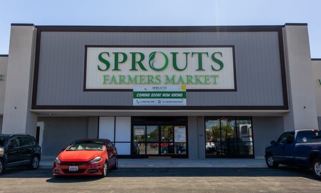 The front of a new supermarket building with the name "Sprouts Farmers Market" and a sign that says "coming soon.