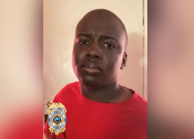 A man in a red shirt with the logo of the Long Beach Police Department.