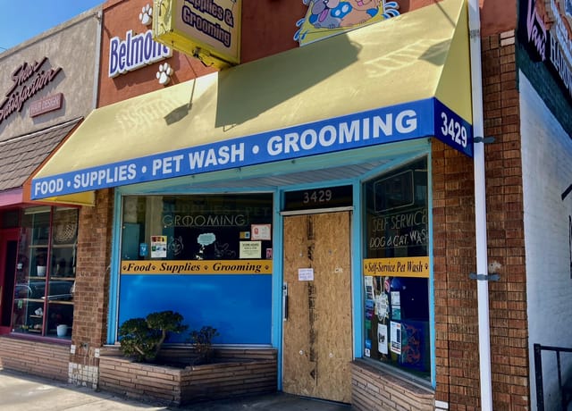 Small storefront with a temporary wooden door to replace the one broken in a recent break-in. 