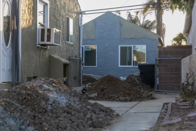 Piles of dirt in front of a house under construction.