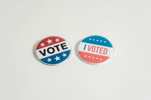 Two red, white and blue buttons, saying Vote and I Voted, respectively.