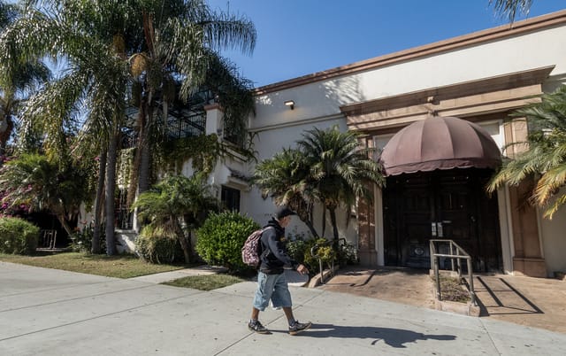 A man walks by a nondescript restaurant.