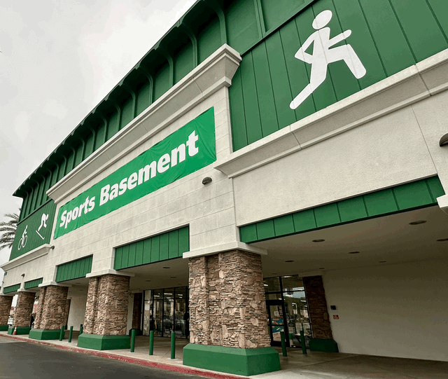 Green and white storefront with a sign saying “Sports Basement.”