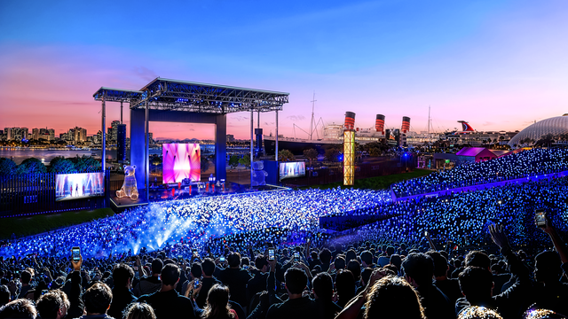 Image of people at an outdoor concert at sunset.