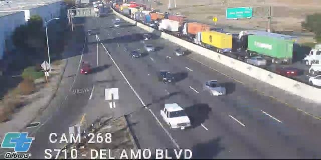 Fuzzy screenshot from a video showing a traffic backed up on one side of a freeway.