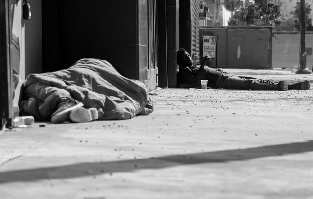 Two people lay on the ground in a black and white photo.