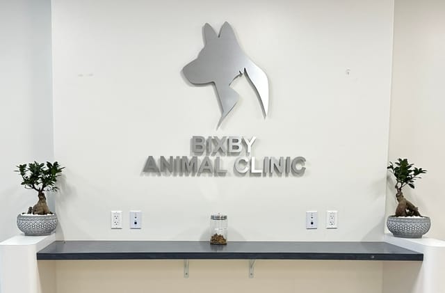 A sign on the wall showing the silhouette of a dog's head and the words "Bixby Animal Clinic."