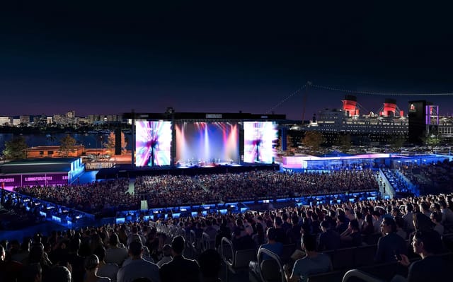 Artist’s rendering of a large, crowded amphitheater in a city at night.