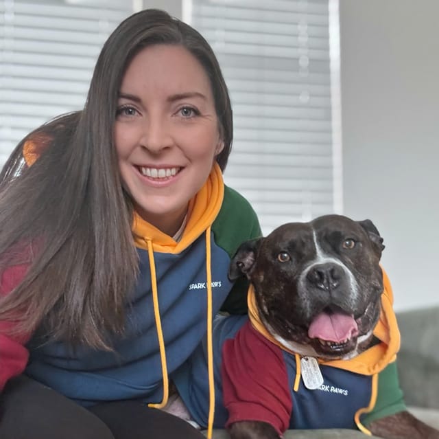 A woman sits close to a really good dog.